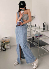 Vestido vaquero azul ajustado con cuello halter, bolsillos abotonados y espalda descubierta, sin mangas